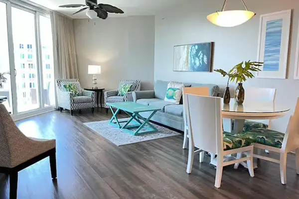 A living room with white furniture and wooden floors.