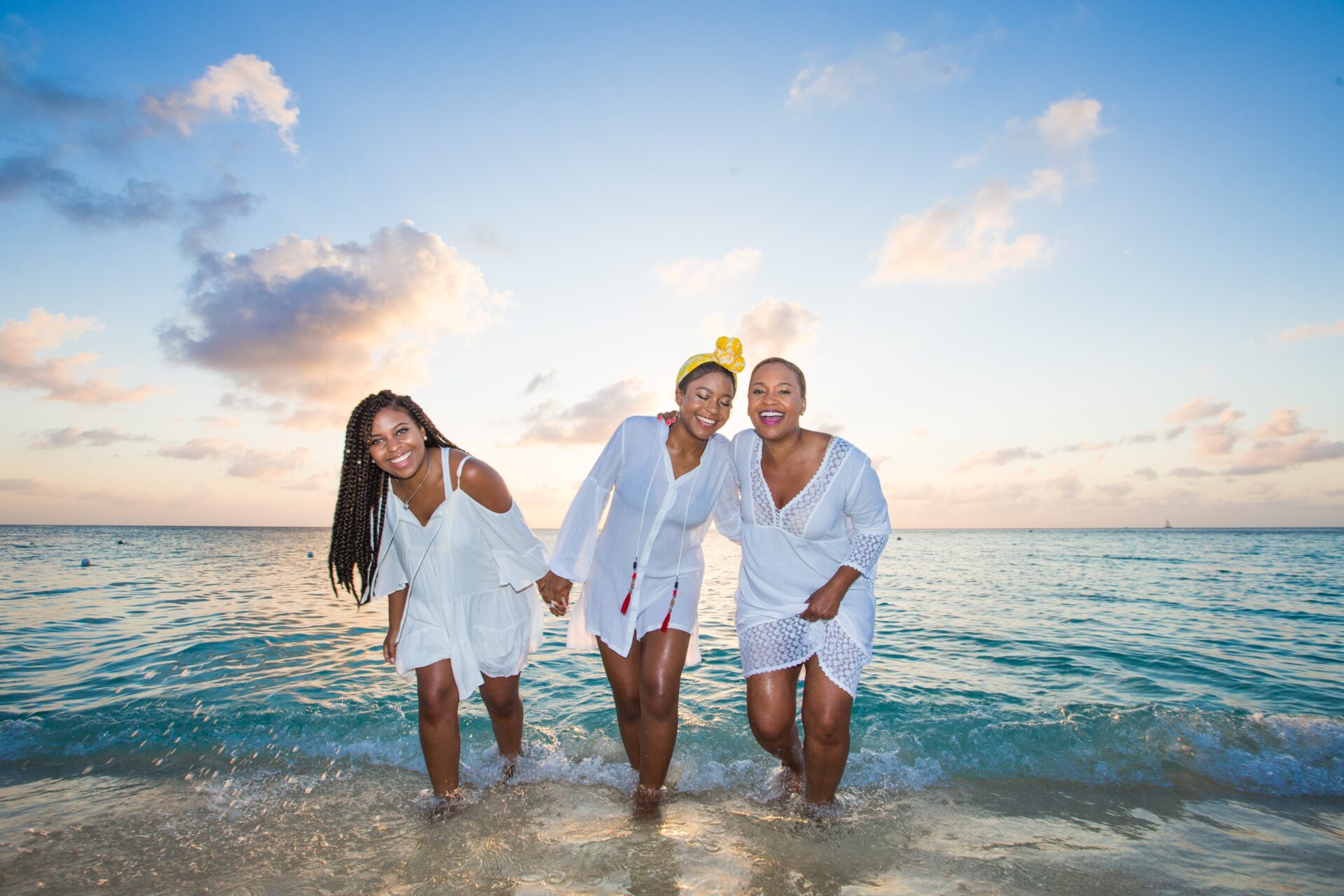 Three women in white are posing for a picture.