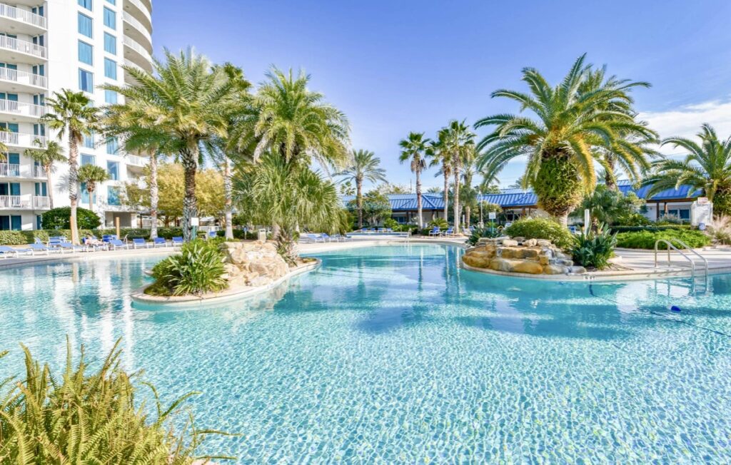 A pool with palm trees and a blue sky