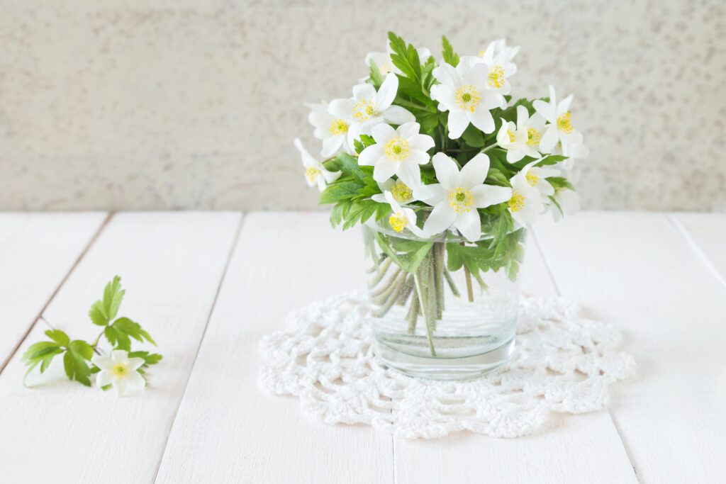 A vase filled with white flowers on top of a table.