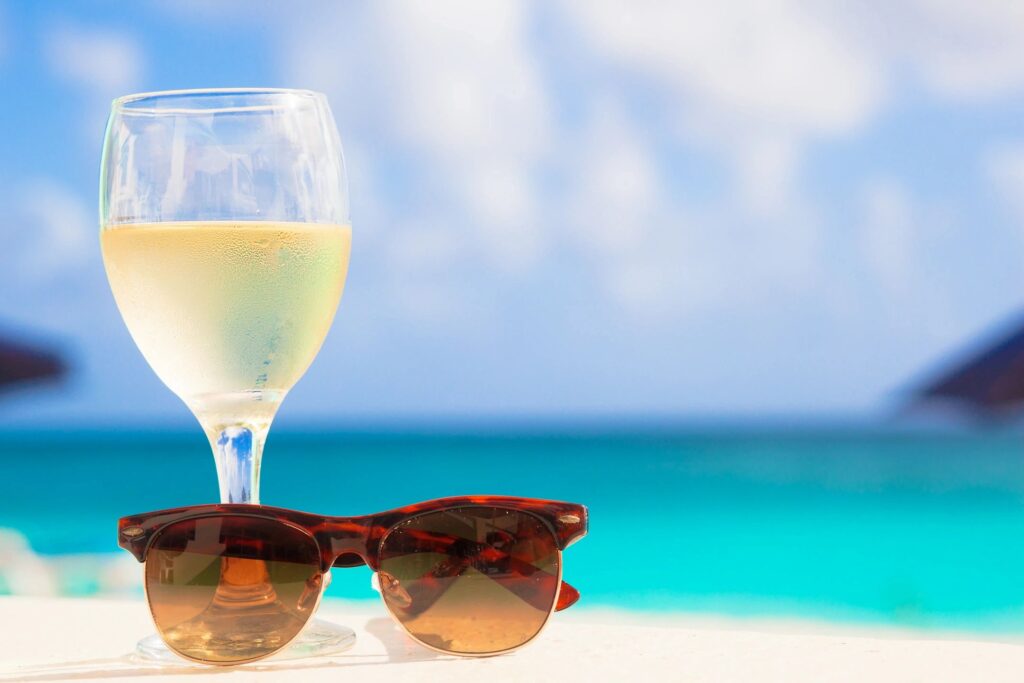 A glass of wine and sunglasses on the beach